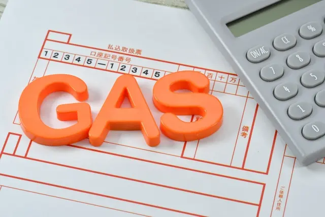 払込取扱票の上に並べられた「GAS」の文字と電卓