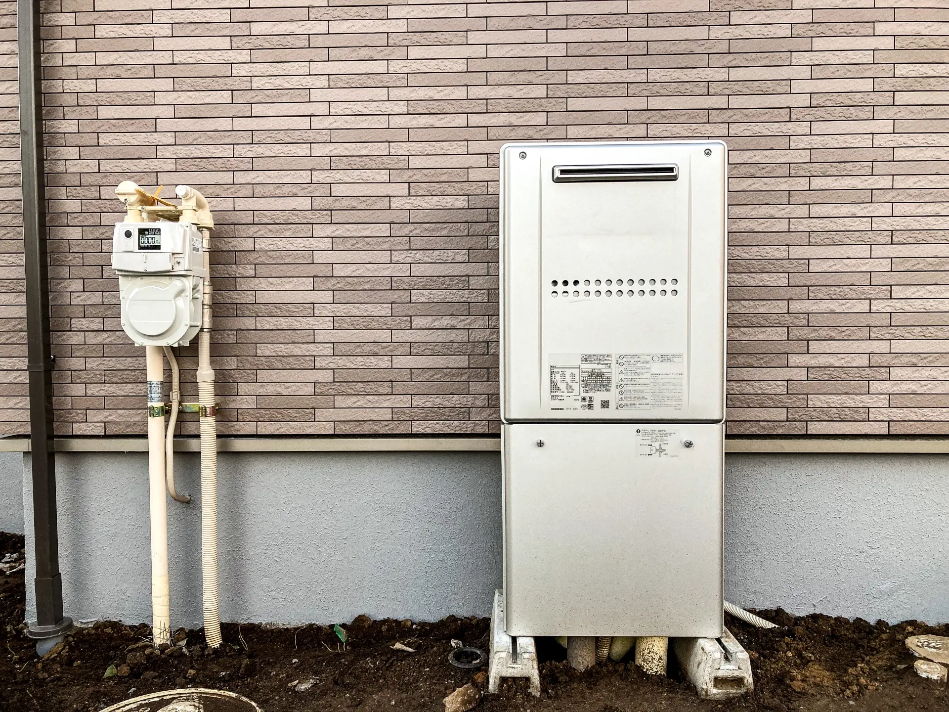 住宅の外壁に設置されたガスメーターと給湯器